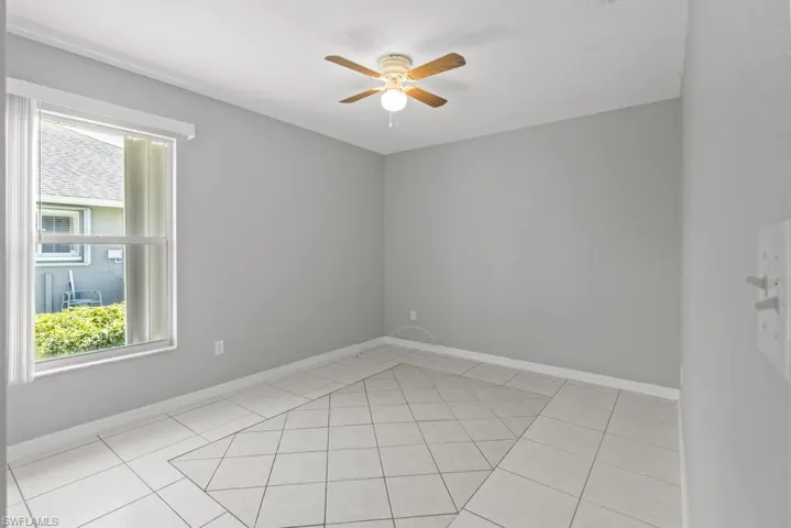 Spare room with ceiling fan and light tile patterned floors