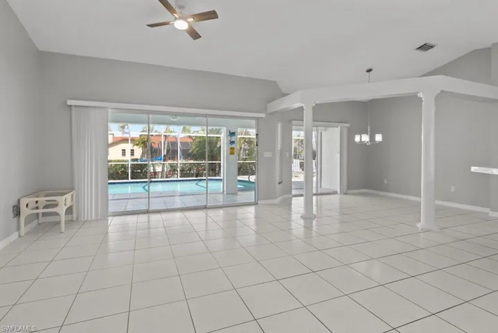 Unfurnished room featuring a ceiling fan, light tile patterned floors, and lofted ceiling