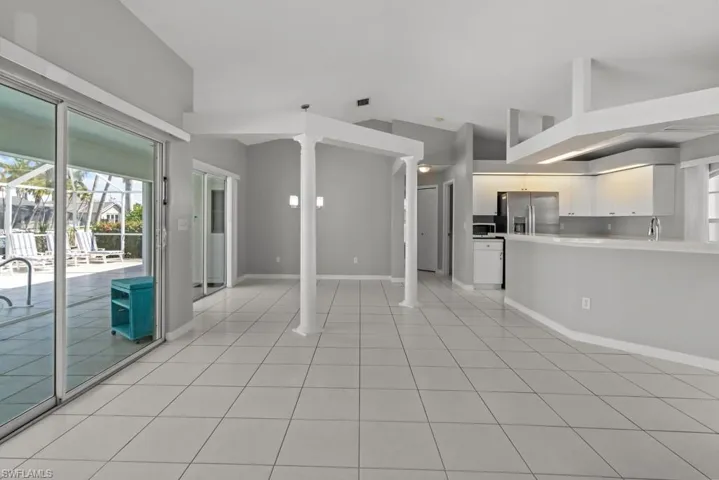 Unfurnished living room featuring baseboards and light tile patterned flooring