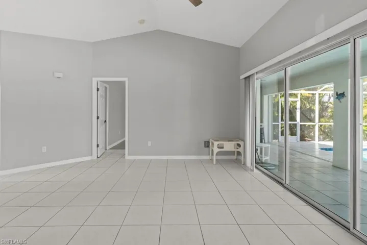 Empty room with a ceiling fan and light tile patterned floors