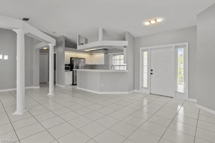 Entryway with light tile patterned floors and decorative columns