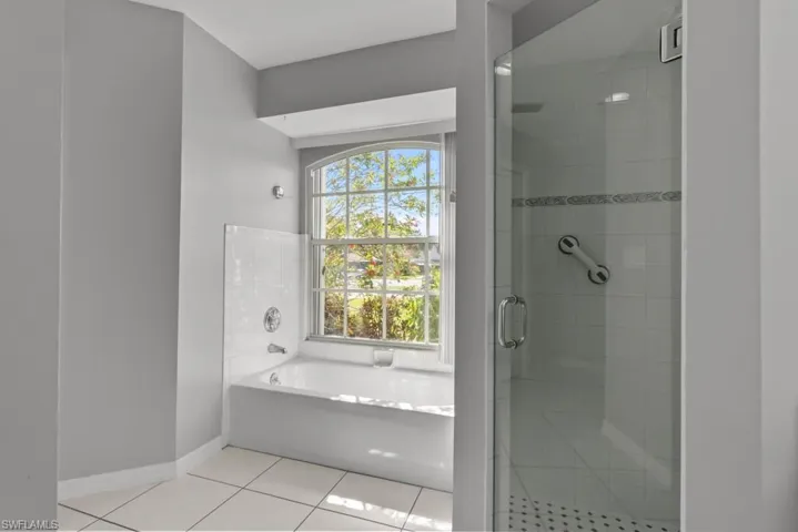 Master bathroom with a garden tub, a stall shower, and light tile patterned floors