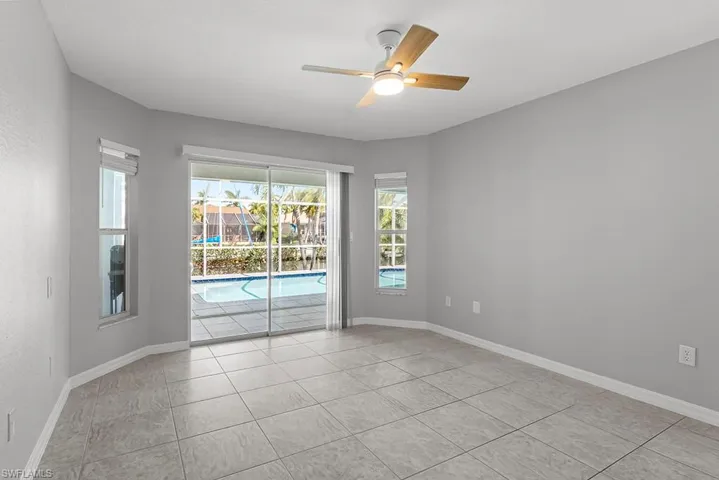Master bedroom with a sunroom, a ceiling fan, and light tile patterned floors