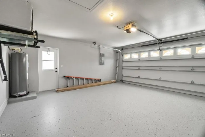 Garage with electric water heater, a garage door opener, and electric panel