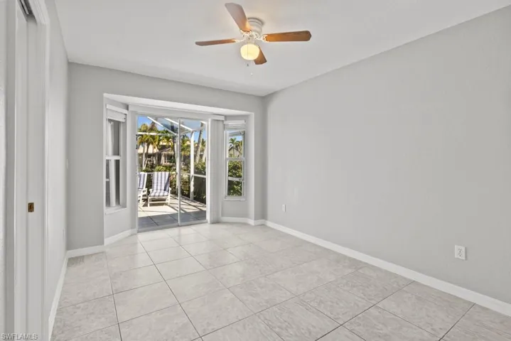Empty room featuring ceiling fan and light tile patterned floors