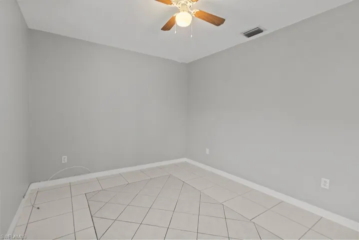 Empty room with baseboards and a ceiling fan