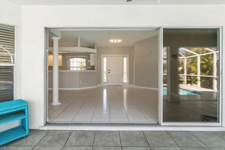 View of living room through sliders from patio/pool area