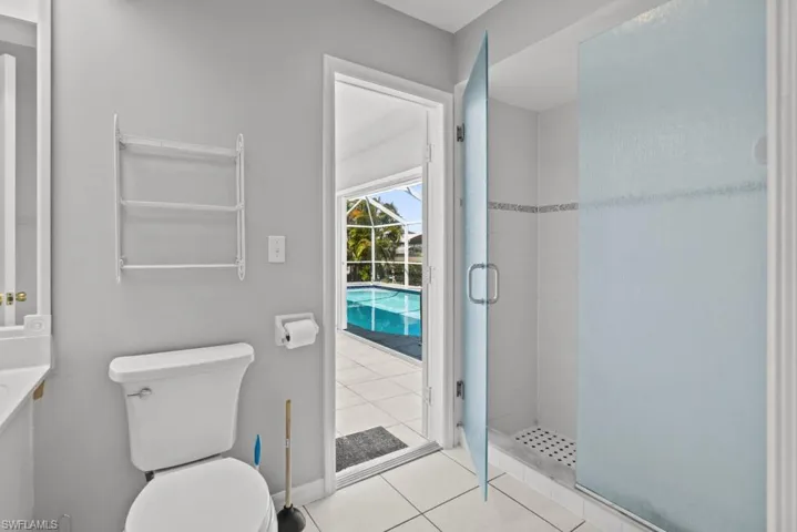 Bathroom featuring a shower stall, light tile patterned floors, and vanity