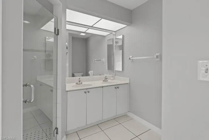 Master bath featuring double vanity, a stall shower, and light tile patterned floors