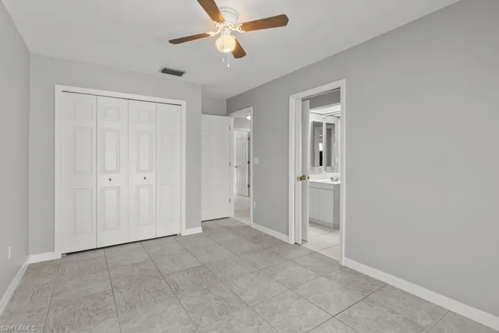 Master bedroom featuring a ceiling fan, a closet, and light tile patterned floors