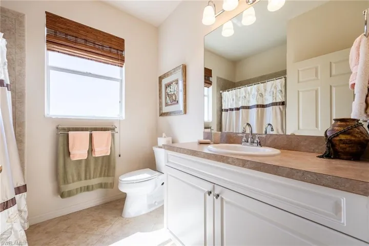 Full bathroom with vanity, a shower with shower curtain, and light tile patterned floors