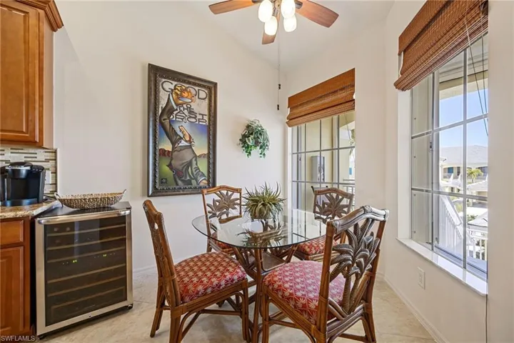 Dining area with beverage cooler, ceiling fan, and light tile patterned floors