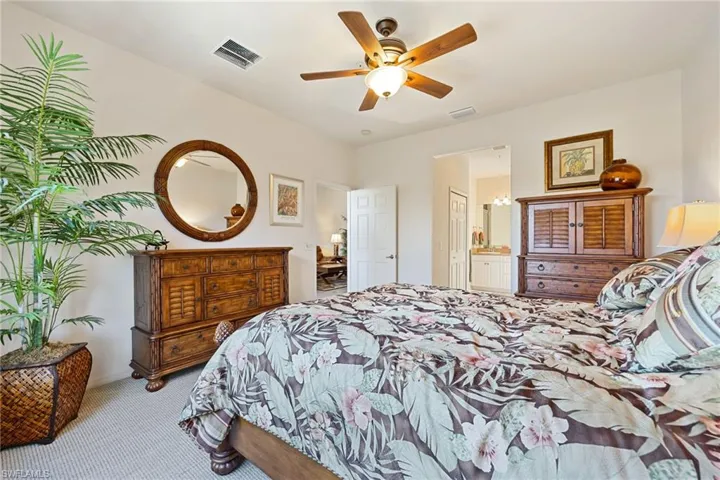 Bedroom featuring carpet flooring, a ceiling fan, and connected bathroom