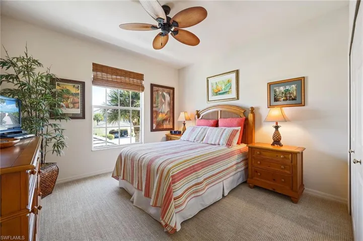 Bedroom with light carpet and a ceiling fan