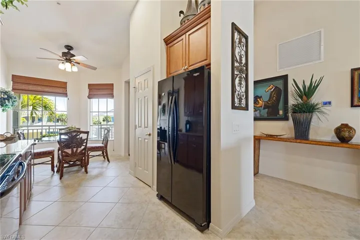 Kitchen featuring black appliances, light tile patterned floors, and ceiling fan
