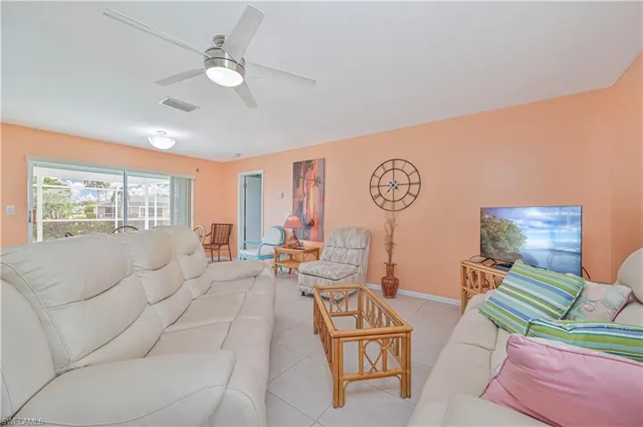 Living area with tile patterned floors and a ceiling fan
