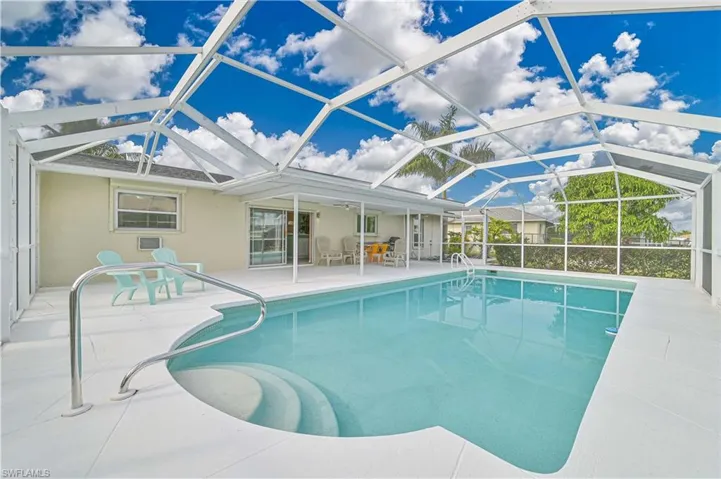 Swimming pool with a sunroom, a patio area, and a lanai
