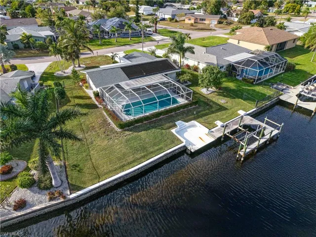 Aerial view of residential area with a pool area and a large body of water