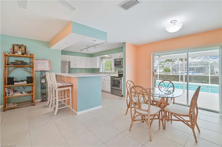 Dining area featuring rail lighting and light tile patterned floors