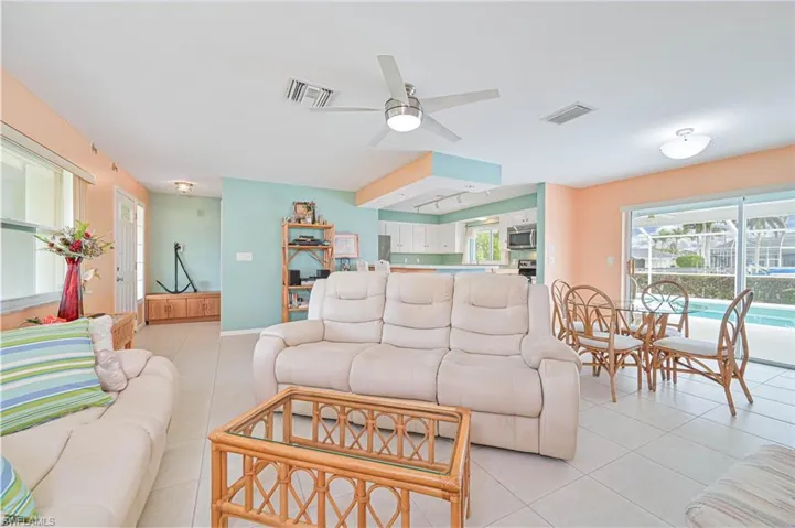 Living room with light tile patterned floors and a ceiling fan