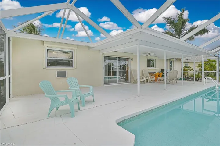 Outdoor pool featuring a sunroom, a patio area, and a lanai