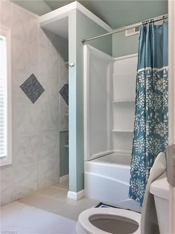 5460- Master Bathroom Upstairs- featuring tile patterned flooring, toilet, and shower / bath combination.