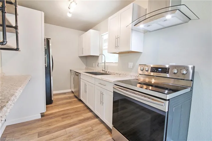 5460-Kitchen featuring white cabinetry, sink, stainless steel fridge with ice dispenser, and hardwood / wood-style flooring