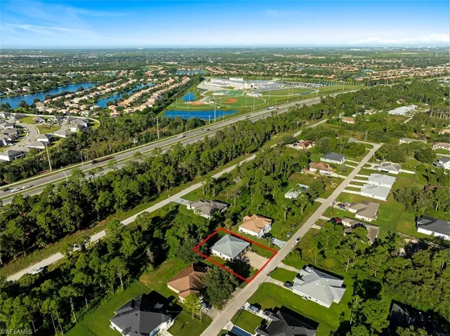 Aerial perspective of suburban area featuring property boundaries highlighted and a large body of water