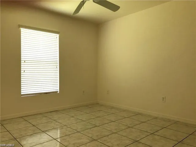 Spare room with light tile patterned flooring and a ceiling fan