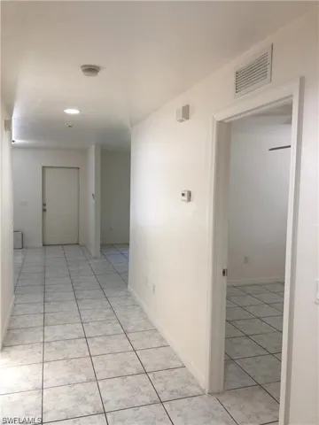 Corridor featuring light tile patterned flooring and baseboards