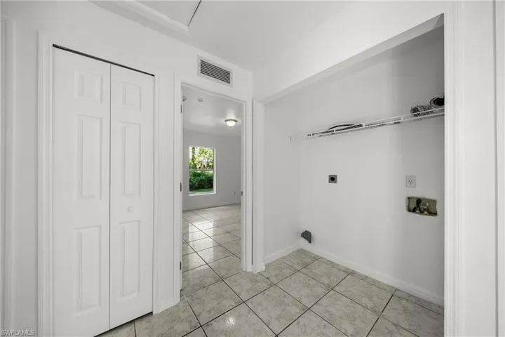 Laundry area with light tile patterned floors, hookup for a washing machine, and hookup for an electric dryer