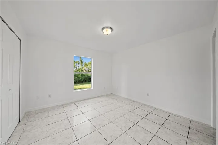 Unfurnished bedroom featuring a closet and light tile patterned floors