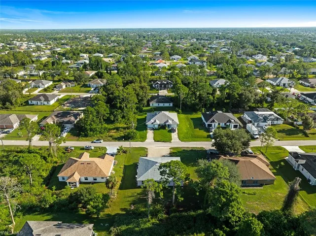Aerial view of property and surrounding area featuring nearby suburban area