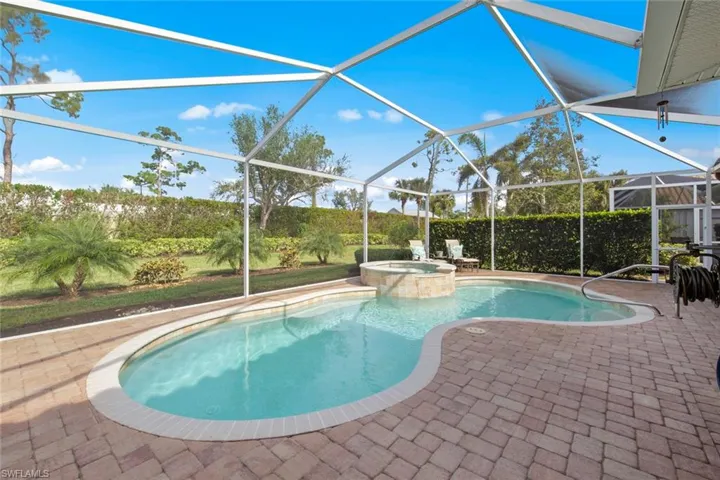 View of swimming pool featuring a lanai, a patio area, and an in ground hot tub