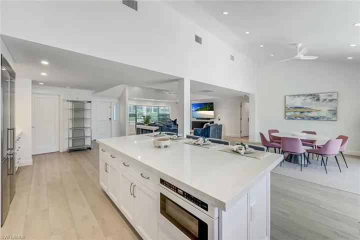 Spacious kitchen island with light-colored countertop and built-in microwave