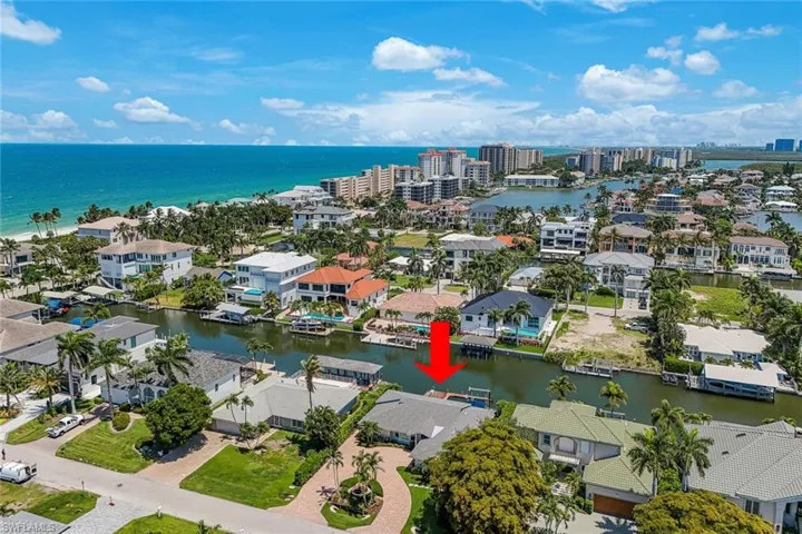 Waterfront property with direct canal access, featuring a private dock and lush tropical landscaping