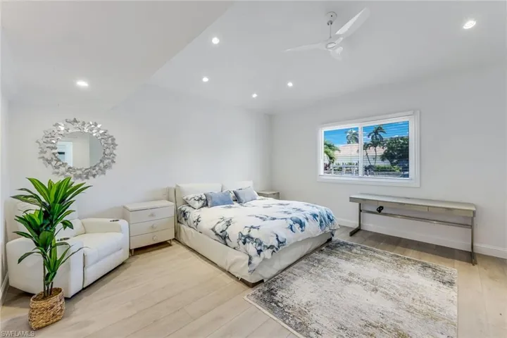 Primary Bedroom featuring wood-finish flooring, recessed lighting, a ceiling fan, and a large window with horizontal blinds