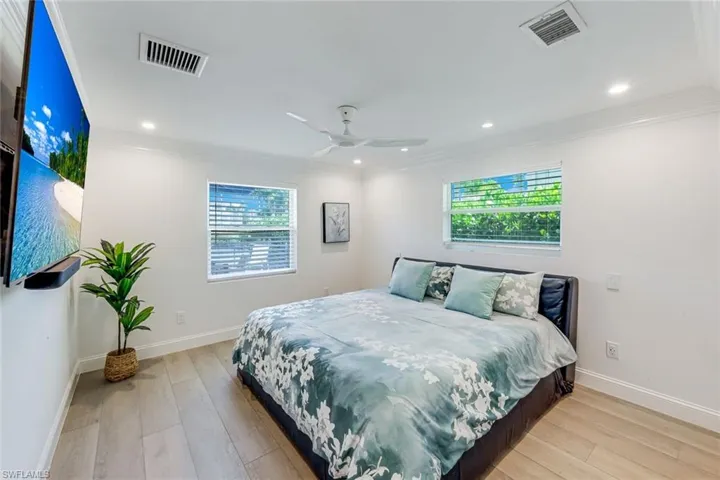 Guest Bedroom Bright room featuring light wood-finish flooring