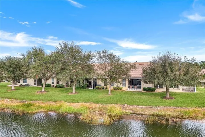 Back of house featuring a water view and a yard