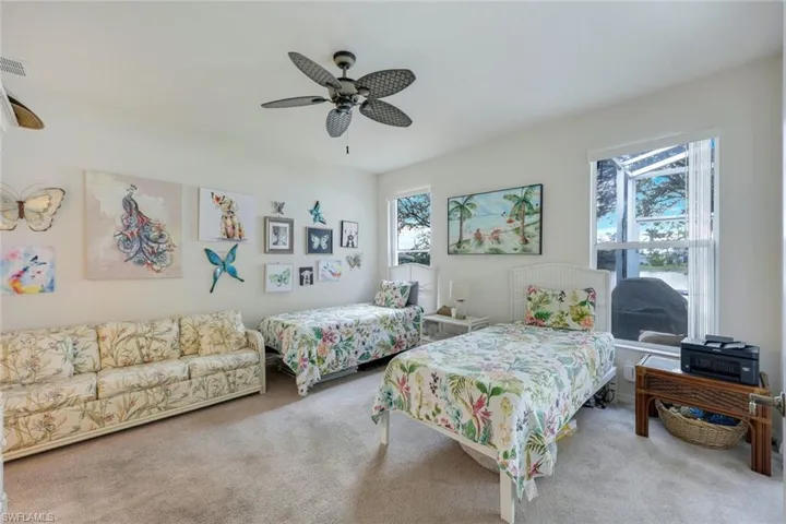 Carpeted bedroom featuring ceiling fan