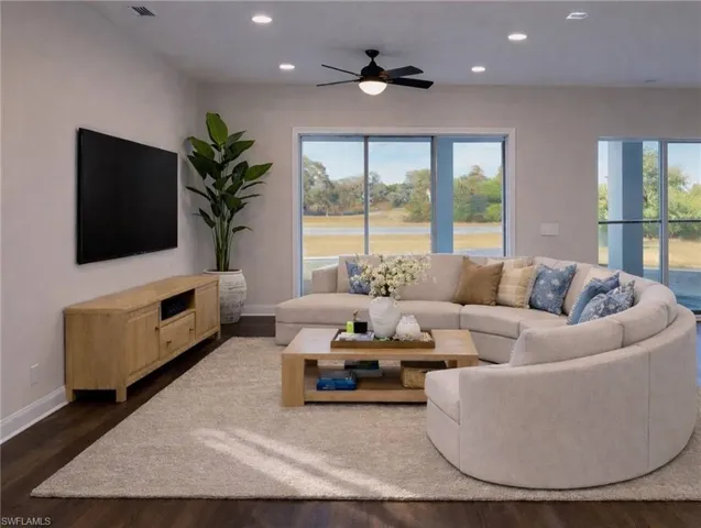 Living room with dark wood-style floors, a ceiling fan, and recessed lighting
