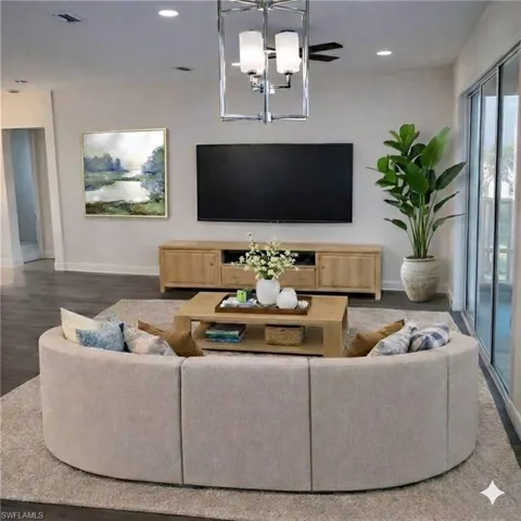 Living room with baseboards and suspended lighting