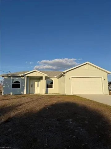 Ranch-style home with concrete driveway, an attached garage, a shingled roof, and stucco siding