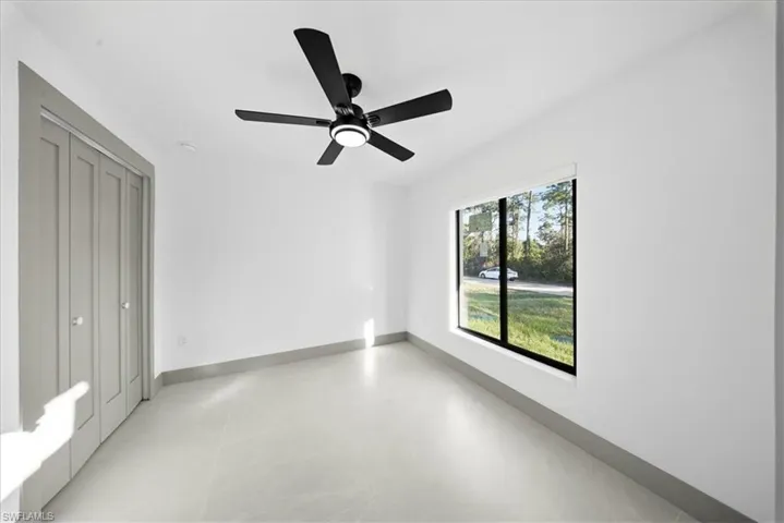 Unfurnished bedroom with ceiling fan and a closet
