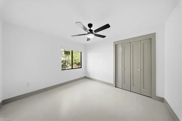 Kitchen with stainless steel appliances, a peninsula, modern cabinets, hanging light fixtures, and light stone counters