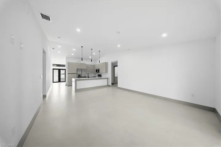 Unfurnished dining area with a high ceiling, a chandelier, french doors, and ceiling fan