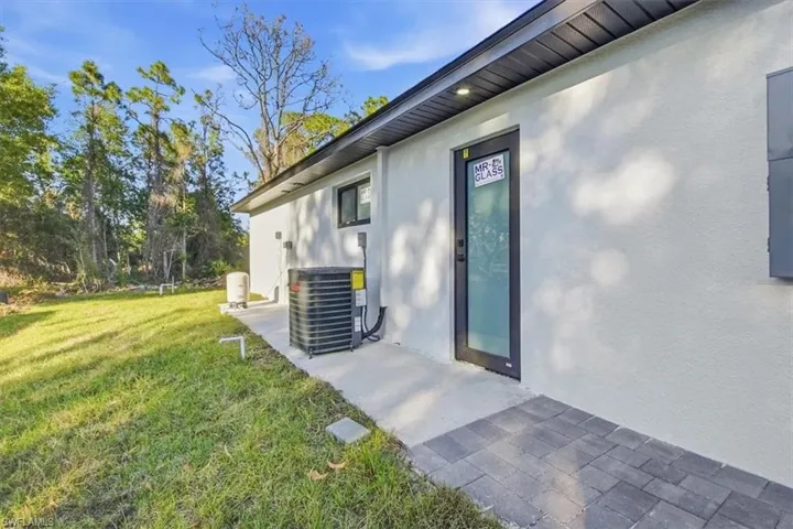 View of side of property featuring a yard and stucco siding