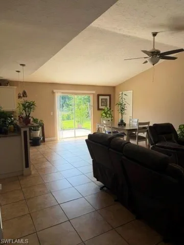 Living area with a ceiling fan and light tile patterned floors