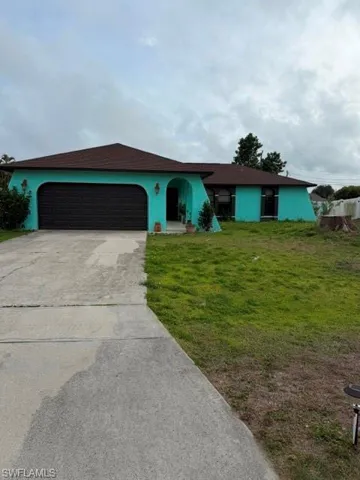 Single story home featuring stucco siding, driveway, a garage, a front yard, and roof with shingles