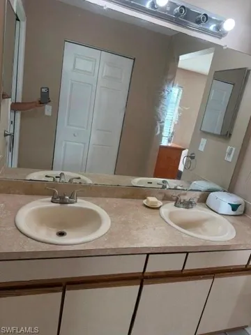 Full bath with double vanity and a closet